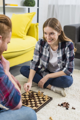 Mann und Frau spielen zuhause Schach