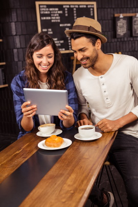 Zwei alleinerziehende Singles sitzen im Café mit Tablet
