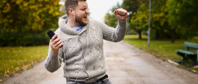 Single-Mann läuft glücklich tanzend durch den Park
