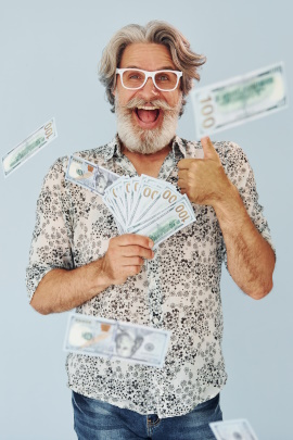 Alter grauhaariger Mann mit Bart wirft Geldscheine