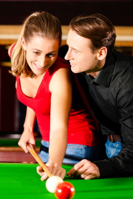 Mann und Frau spielen Billard beim Date
