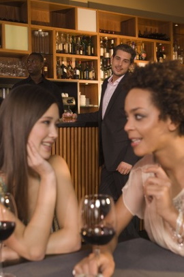 Mann beobachtet zwei Freundinnen in der Bar