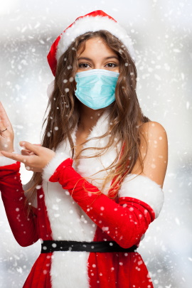 Weihnachtsfrau mit Maske vor Winterlandschaft stehend