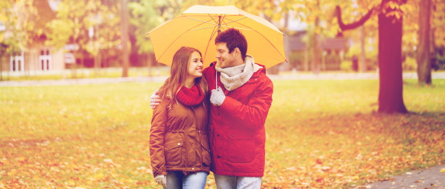 Paar mit Regenschirm hat Date bei schlechtem Wetter