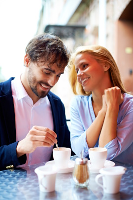 Verliebtes Paar sitzt beim Date draußen am Café