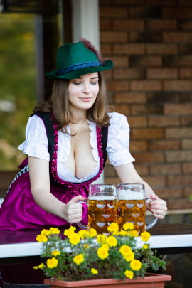 Frau im Dirndl mit zwei Bierkrügen in den Händen