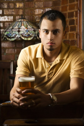 Mann sitzt allein in der Bar beim Drink