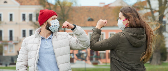 Mann spricht Frau mit Maske an während Corona