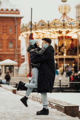 Paar umarmt sich auf dem Weihnachtsmarkt
