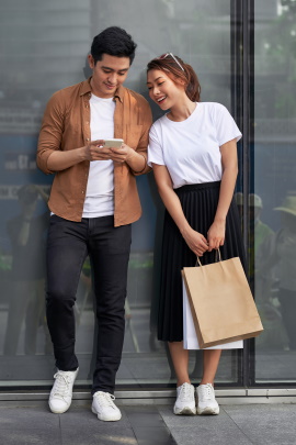 Mann und Frau in der Stadt schauen aufs Handy