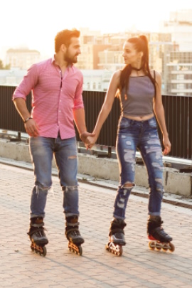 Paar hält Händchen beim Inline-Skates fahren