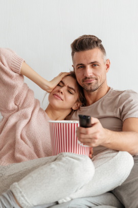 Paar sitzt zu Hause gelangweilt vor dem Fernseher