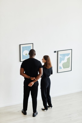 Mann und Frau betrachten Gemälde in einer Ausstellung