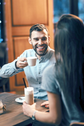 Mann lächelt Frau beim Date im Café an
