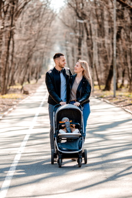 Glückliches Paar geht mit Kinderwagen spazieren