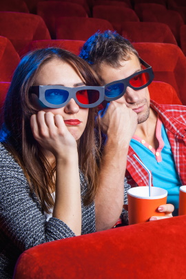 Mann und Frau sitzen gelangweilt im Kinosaal
