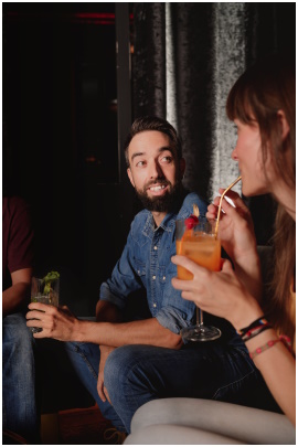 Mann und Frau mit Cocktails reden auf einer Party