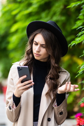 Ex-Partnerin blickt unzufrieden aufs Handy