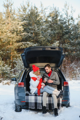 Paar macht Picknick am Auto im Winter