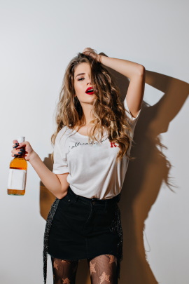 Partygirl mit Bierflasche schaut mit sexy Blick