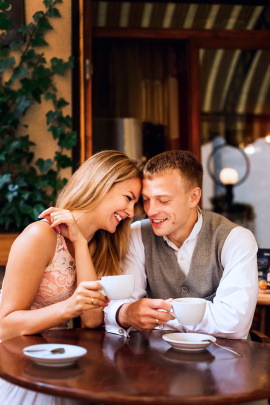 Paar sitzt lachend beim Date im Café