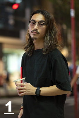 Mann mit Brille und langen schwarzen Haaren