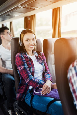 Attraktive Frau sitzt lächelnd im Reisebus