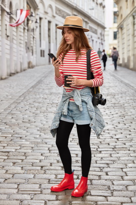 Frau in der Stadt schaut aufs Smartphone