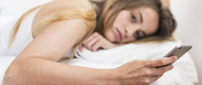 Ex-Freundin liegt im Bett und schaut sehnsüchtig aufs Handy
