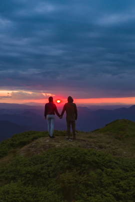 Paar wandert bei Sonnenuntergang über den Berg