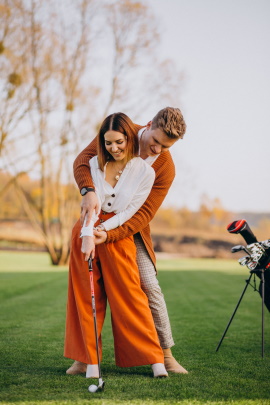 Paar hält zusammen Schläger beim Golf