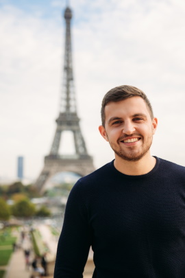 Glücklicher Mann im Urlaub mit Eiffelturm im Hintergrund