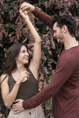 Fröhliches Paar hat Körperkontakt beim Tanzen im Park